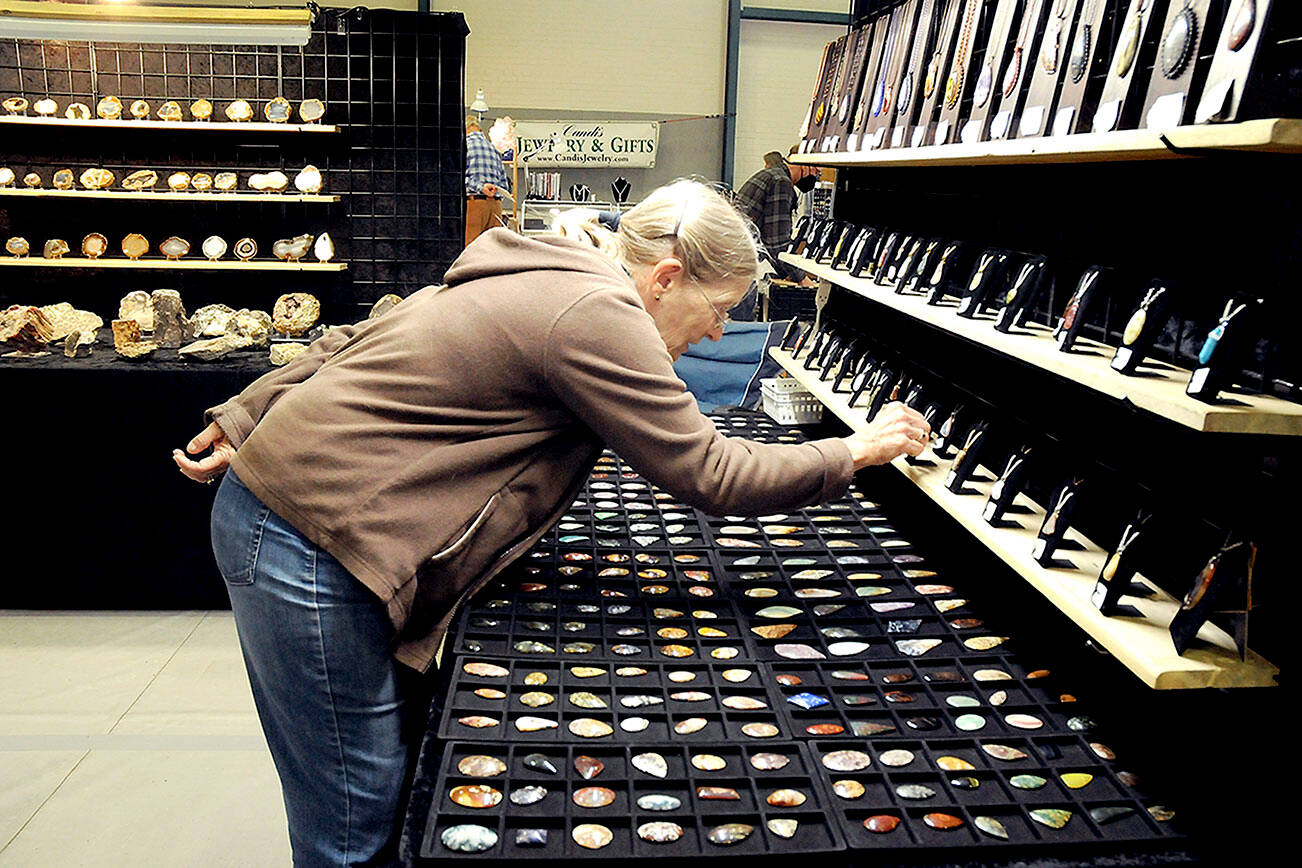 Laurie Nichols of Port Angeles examines a display of gems and pendants at the Rock, Gem & Jewelry Show at Vern Burton Community Center in Port Angeles. The show, hosted by the Clallam County Gem & Mineral Association over the weekend, featured a wide variety of rocks, minerals, crystals and fossils from around the world for sale and for show. (Keith Thorpe/Peninsula Daily News)
