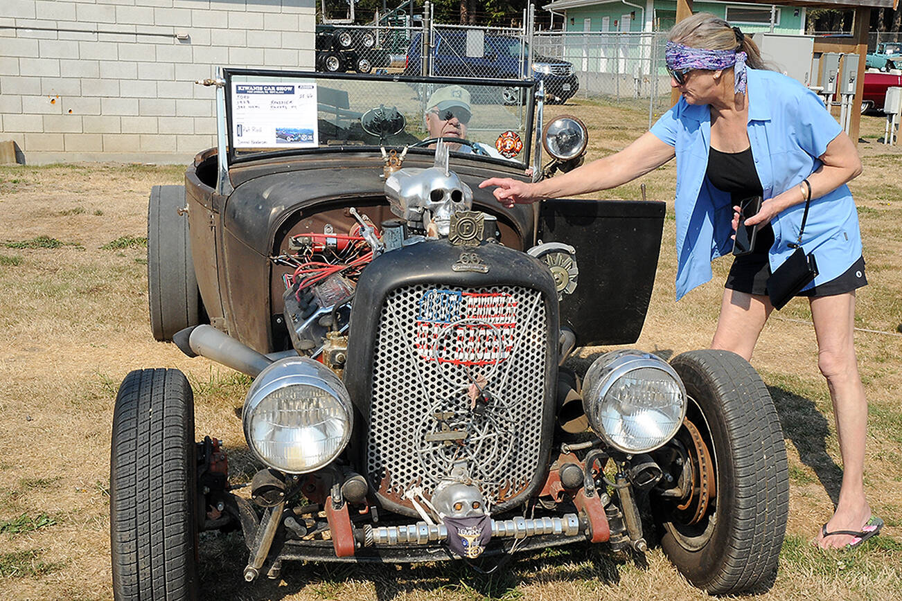 KEITH THORPE/PENINSULA DAILY NEWS
Julie Moen of Port Angeles, right, points the quirks of a "rat rod" built from a 1928 Ford Roadster by Dennis Broderson of Port Angeles, in drivers seat, during Saturday's Kiwanis Car Show at the Clallam County Fairgrounds in Port Angeles. The event a fundraiser hosted by the Kiwanis Club of Port Angeles, featured more than 70 vintage and customized autos and trucks.