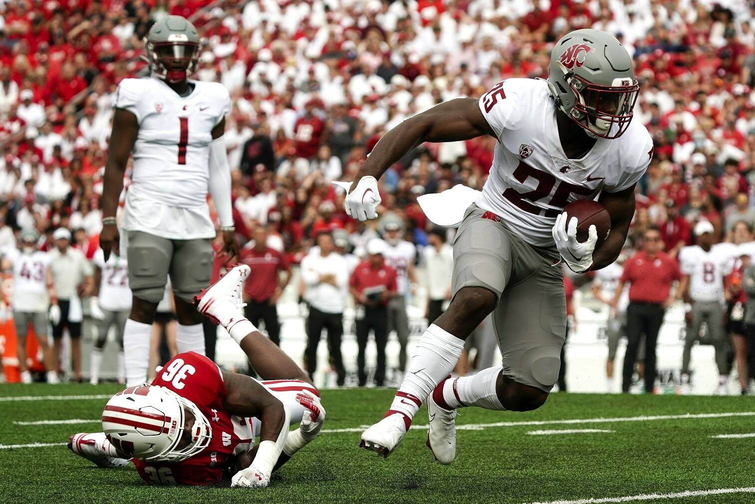 Washington State's Nakia Watson (25) runs past Wisconsin's Jake Chaney (36) during the first half of an NCAA college football game Saturday in Madison, Wis. (AP Photo/Morry Gash)