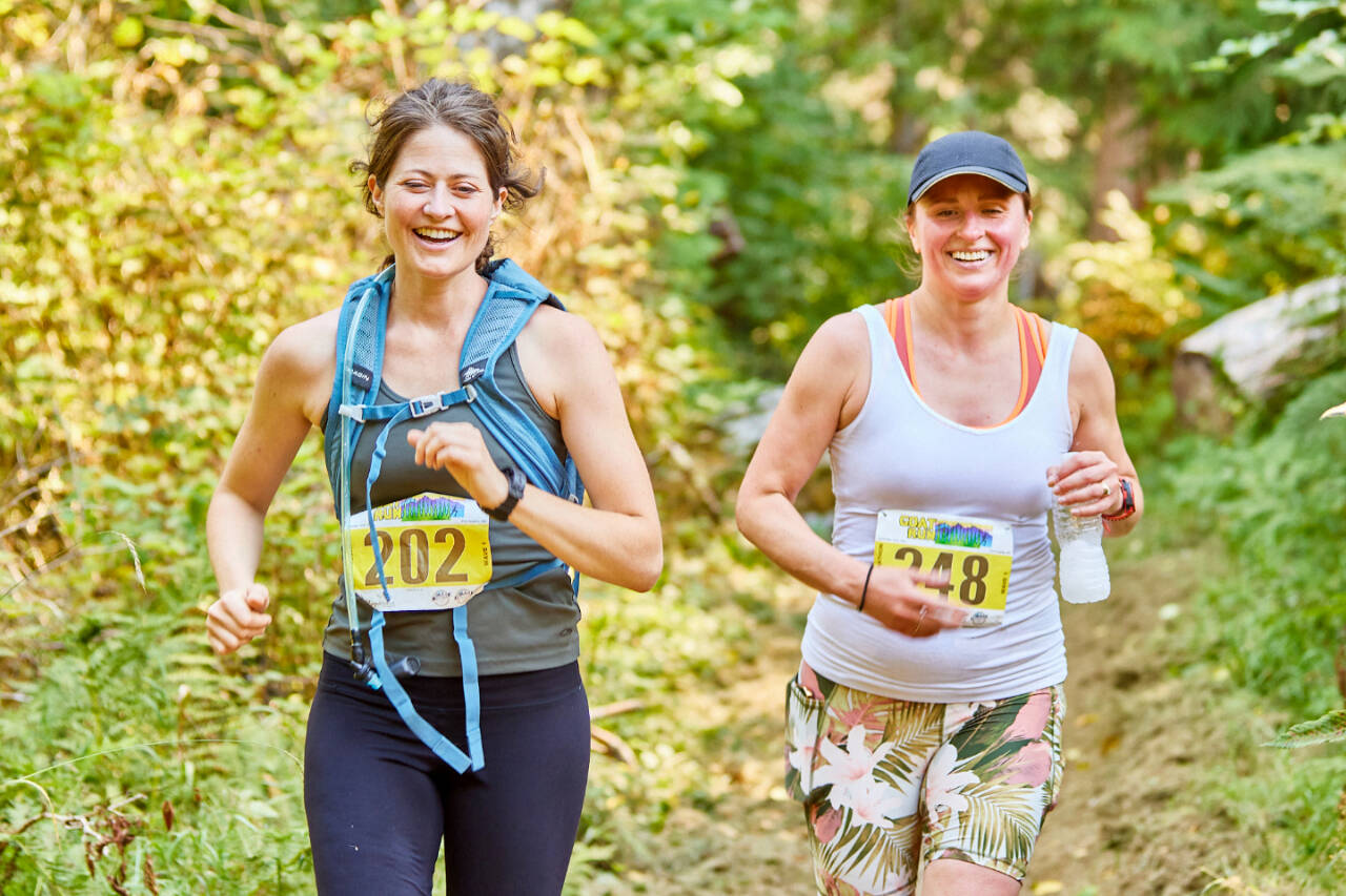 Lauren Bailey of Port Angeles, left, and Victoria Hall of Sequim run in the GOAT Run half-marathon along the Great Olympic Discovery Trail west of Port Angeles this weekend.
Matt Sagen/Cascadia Films