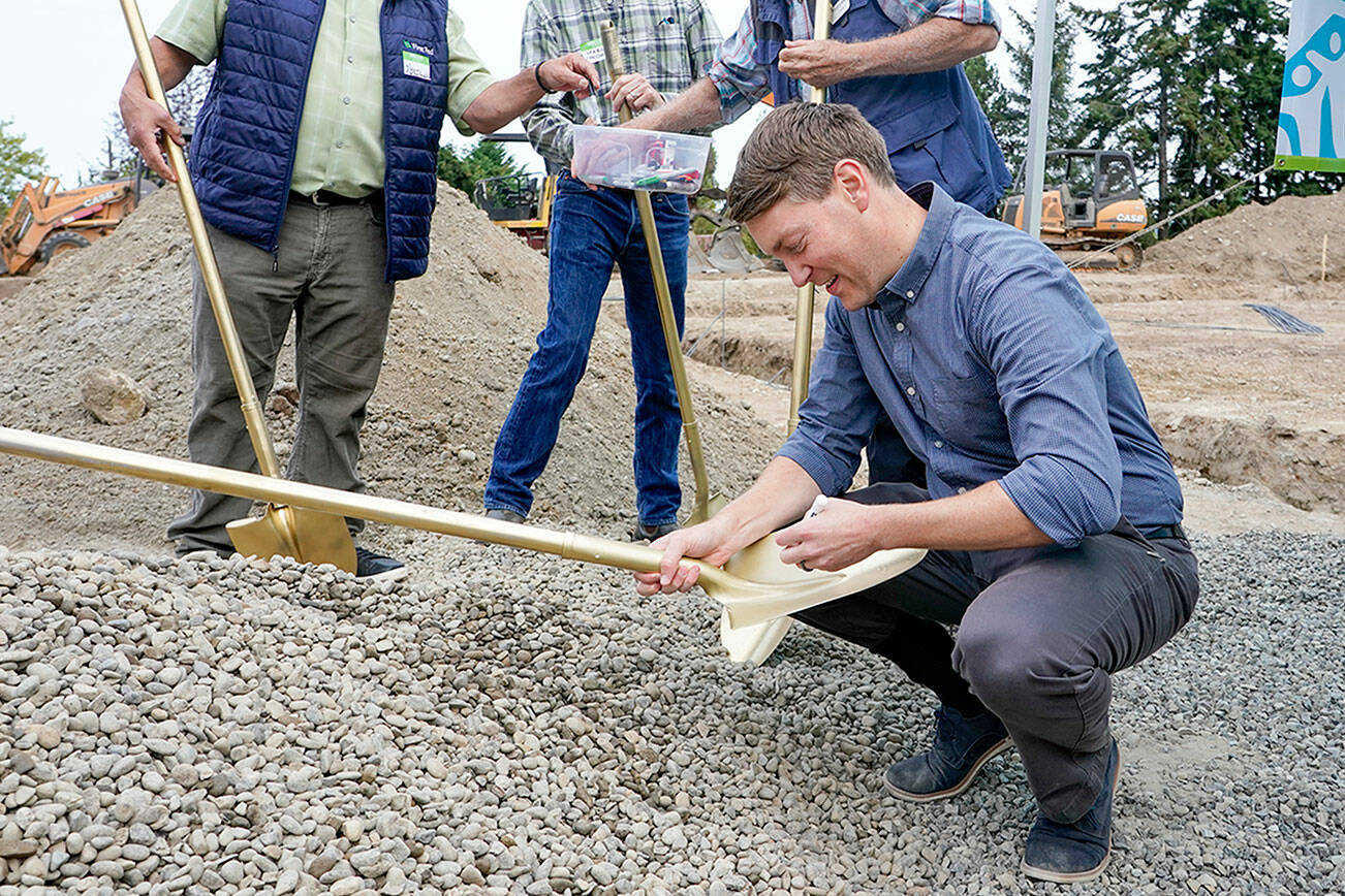 Port Townsend Mayor David Faber signs a ceremonial shovel used in the groundbreaking ceremony for six permanent, affordable housing units being constructed by East Jefferson Habitat for Humanity at 18th and Landes Streets in Port Townsend. This shovel and others will be given to each homeowner upon receiving the keys to their new home. (Steve Mullensky/for Peninsula Daily News)