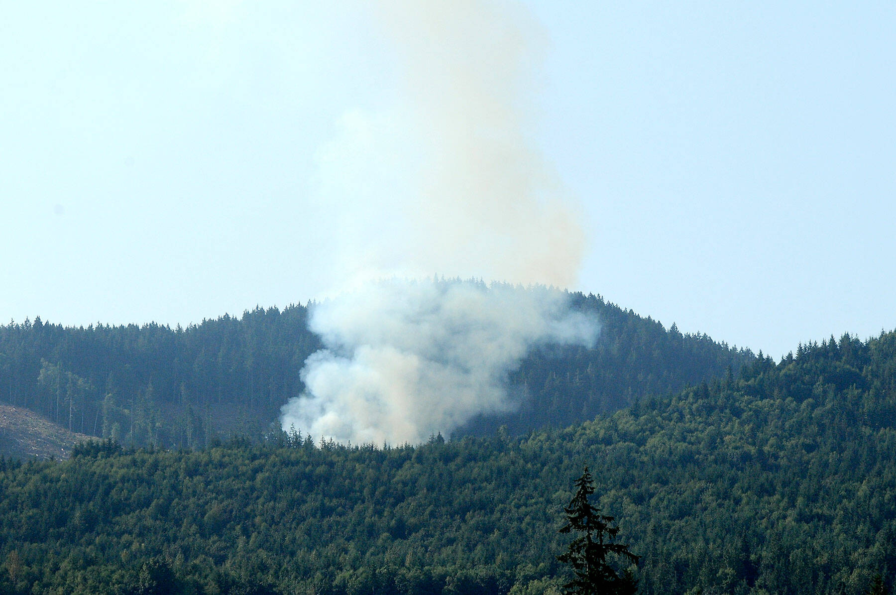 Smoke rises from a wildland fire along a side spur from Joyce Access Road east of Joyce on Thursday. (Keith Thorpe/Peninsula Daily News)
