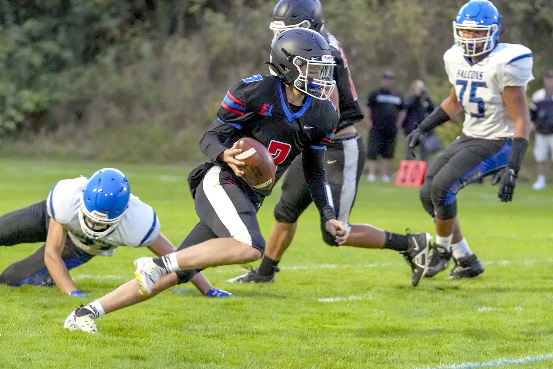 Steve Mullensky/for Peninsula Daily News

Rivals’ QB Cash Holmes eludes a South Whidbey defender and looks for a receiver downfield during a game Friday night at Memorial Field in Port Townsend.