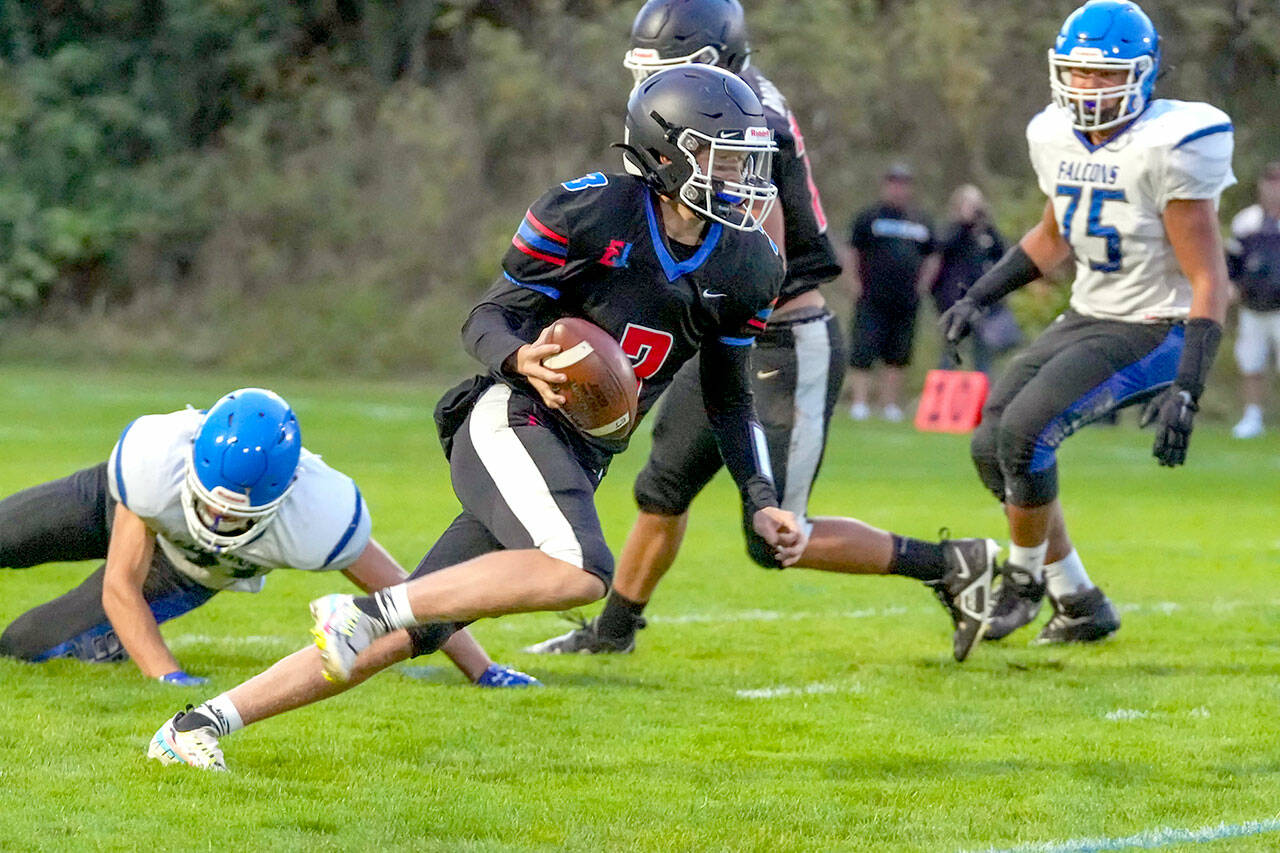 Steve Mullensky/for Peninsula Daily News

Rivals’ QB Cash Holmes eludes a South Whidbey defender and looks for a receiver downfield during a game Friday night at Memorial Field in Port Townsend.