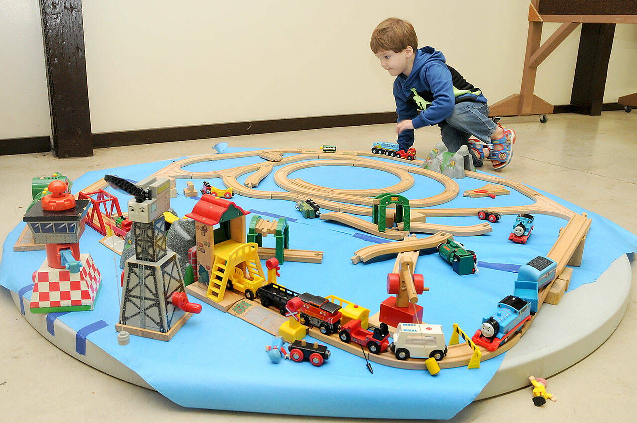 Jackson Chapman, 3, of Sequim plays with a model train display during the 22nd annual Train Show and Swap Meet on Saturday at the Home Arts Building at the Clallam County Fairgrounds in Port Angeles. The two-day event, hosted by the North Olympic Peninsula Railroaders, featured a variety of model railroad sets and accessories for sale or trade, as well as operating train layouts on display. (Keith Thorpe/Peninsula Daily News)