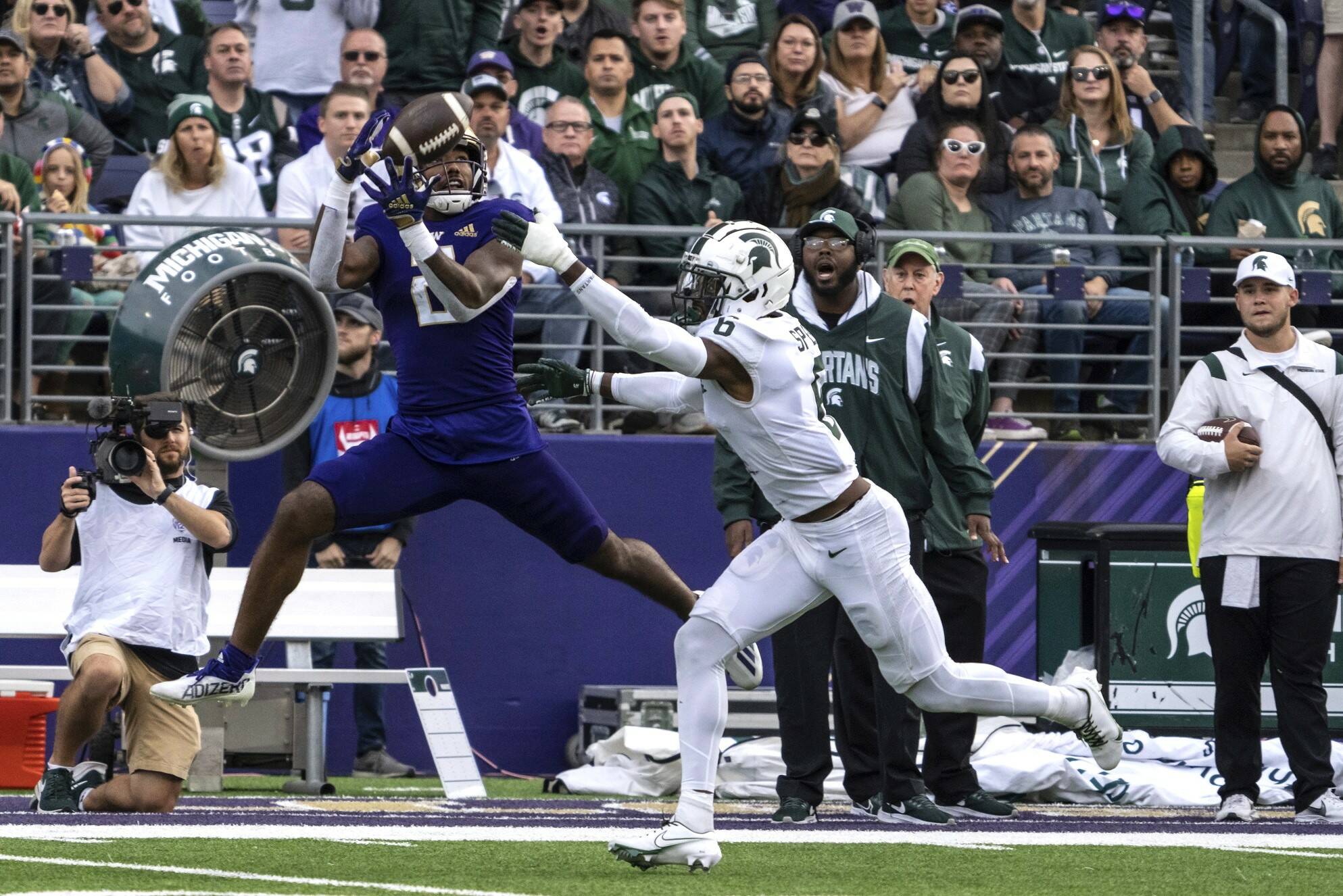 Washington wide receiever Ja'Lynn Polk, left, makes a reception against Michigan State defensive back Ameer Speed during the first half of an NCAA college football game, Saturday, Sept. 17, 2022, in Seattle. (AP Photo/Stephen Brashear)