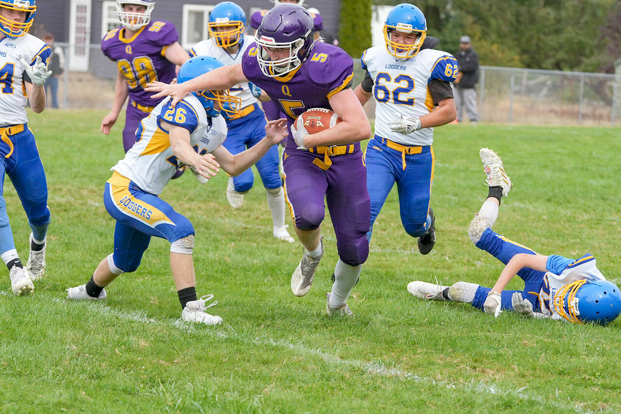 Quilcene Ranger Dominic Smith dashes around Logger Dominiq Sprague during a game in Quilcene on Saturday. (Steve Mullensky/for Peninsula Daily News)