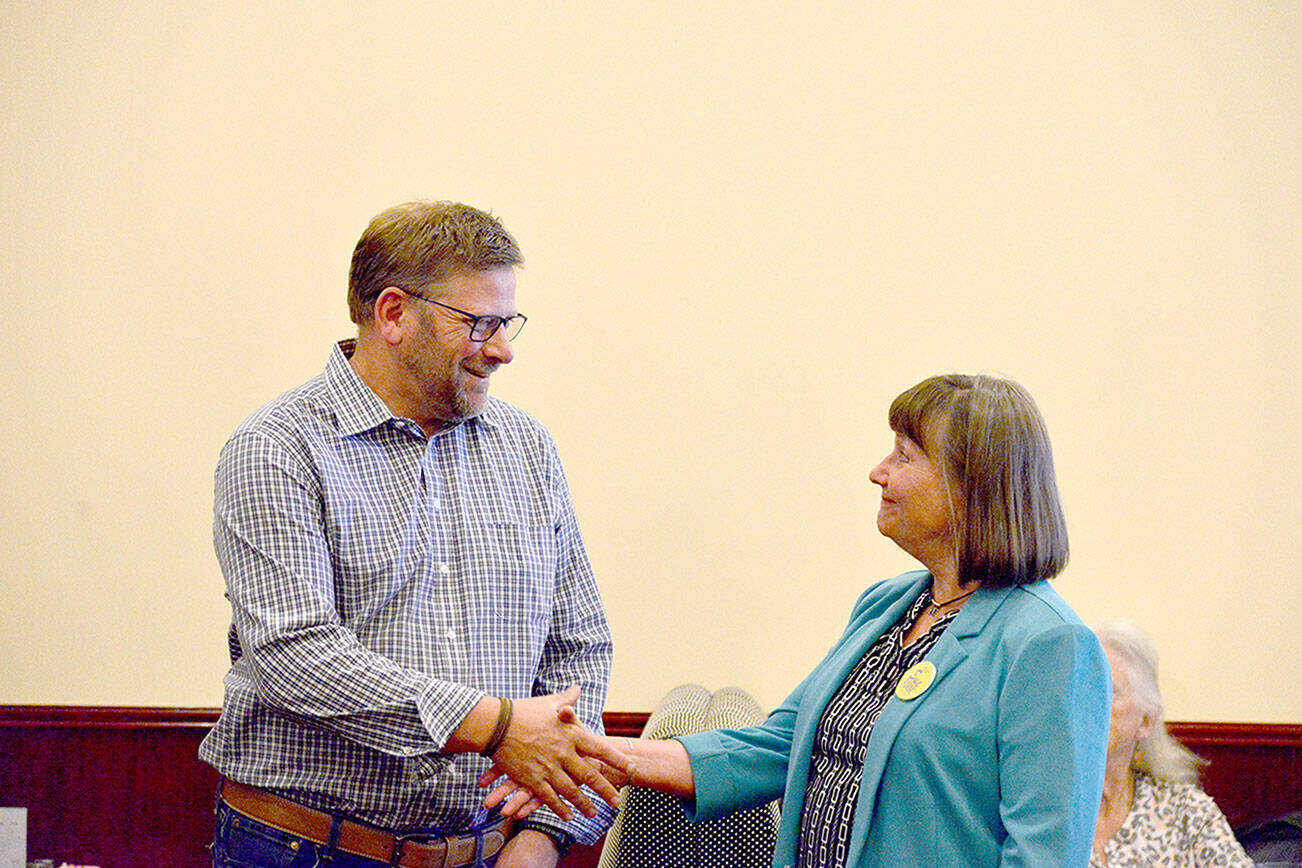 District 24, Position 1, state Rep. Mike Chapman, a Port Angeles Democrat, shakes hands with Republican challenger Sue Forde during a Port Angeles Noon Rotary Club meeting at Asian Buffet restaurant in Port Angeles on Wednesday. (Peter Segall / Peninsula Daily News)