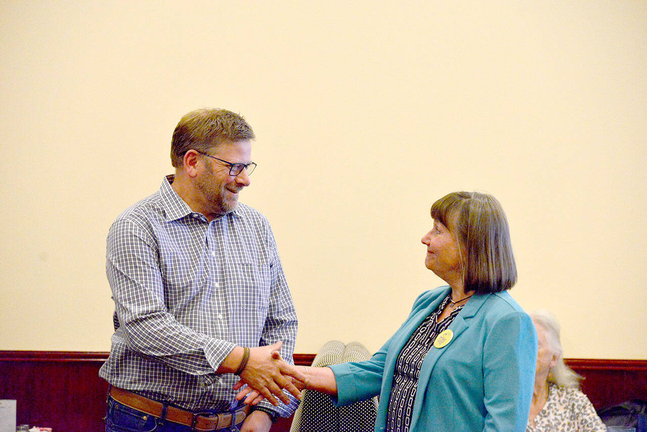 District 24, Position 1, state Rep. Mike Chapman, a Port Angeles Democrat, shakes hands with Republican challenger Sue Forde during a Port Angeles Noon Rotary Club meeting at Asian Buffet restaurant in Port Angeles on Wednesday. (Peter Segall / Peninsula Daily News)