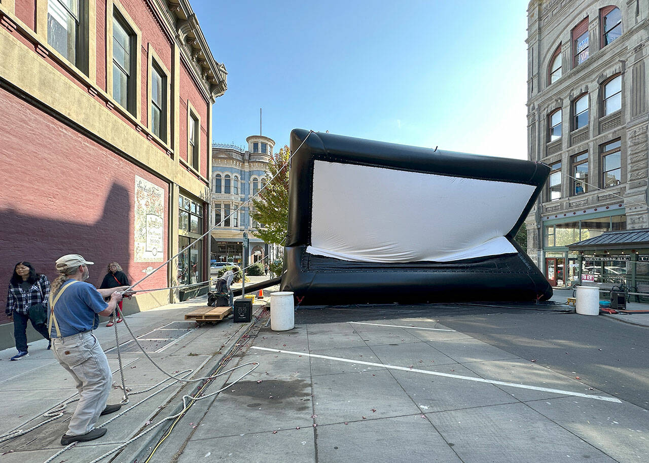 Miles McRae, owner of Full Spectrum Projector and Sound and of the Airscreen, pulls the ropes to control the 15-foot by 30-foot screen as air is pumped into the screen to inflate it for use during the 23rd Port Townsend Film Festival, which started on Thursday. (Steve Mullensky/for Peninsula Daily News)