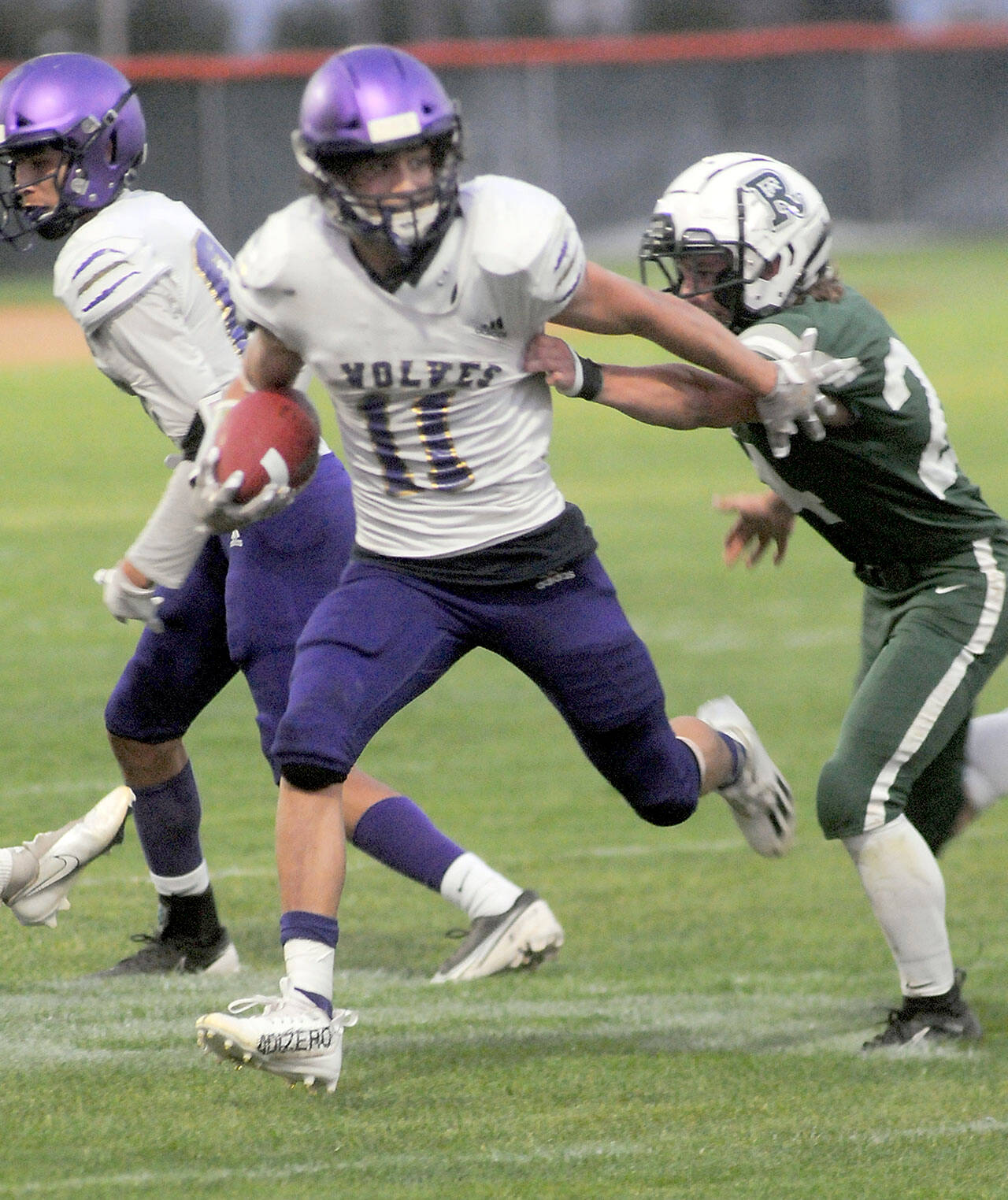 KEITH THORPE/PENINSULA DAILY NEWS
Sequim's Aiden Gockerell, center, fends of the defense of Port Angeles'  James Browning on Friday at Port Angeles Civic Field.