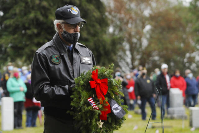 Col. Randy Roberts (U.S. Air Force, ret.) prepares to lay a ceremonial wreath for U.S. military prisoners of war and missing in action at a Wreaths Across American event at Sequim View Cemetery in 2020. Michael Dashiell/Olympic Peninsual News Group