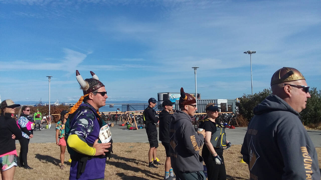 The North Kitsap-based team of Mountain Vikes, complete with Viking helmets, waits for their mountain biker to arrive at the Big Hurt exchange zone. (Pierre LaBossiere/Peninsula Daily News)