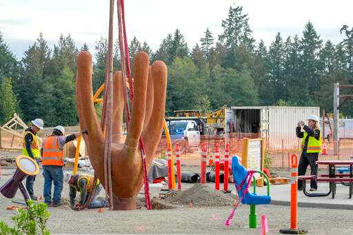 Port Townsend artist Rebecca Welti records the installation of her concrete climbing sculpture, Pluteus, at a new playground area at HJ Carroll Park in Chimacum. The sculpture, in the shape of a baby sea urchin, is totally accessible and represents dependence on life in the Salish Sea. (Steve Mullensky/for Peninsula Daily News)