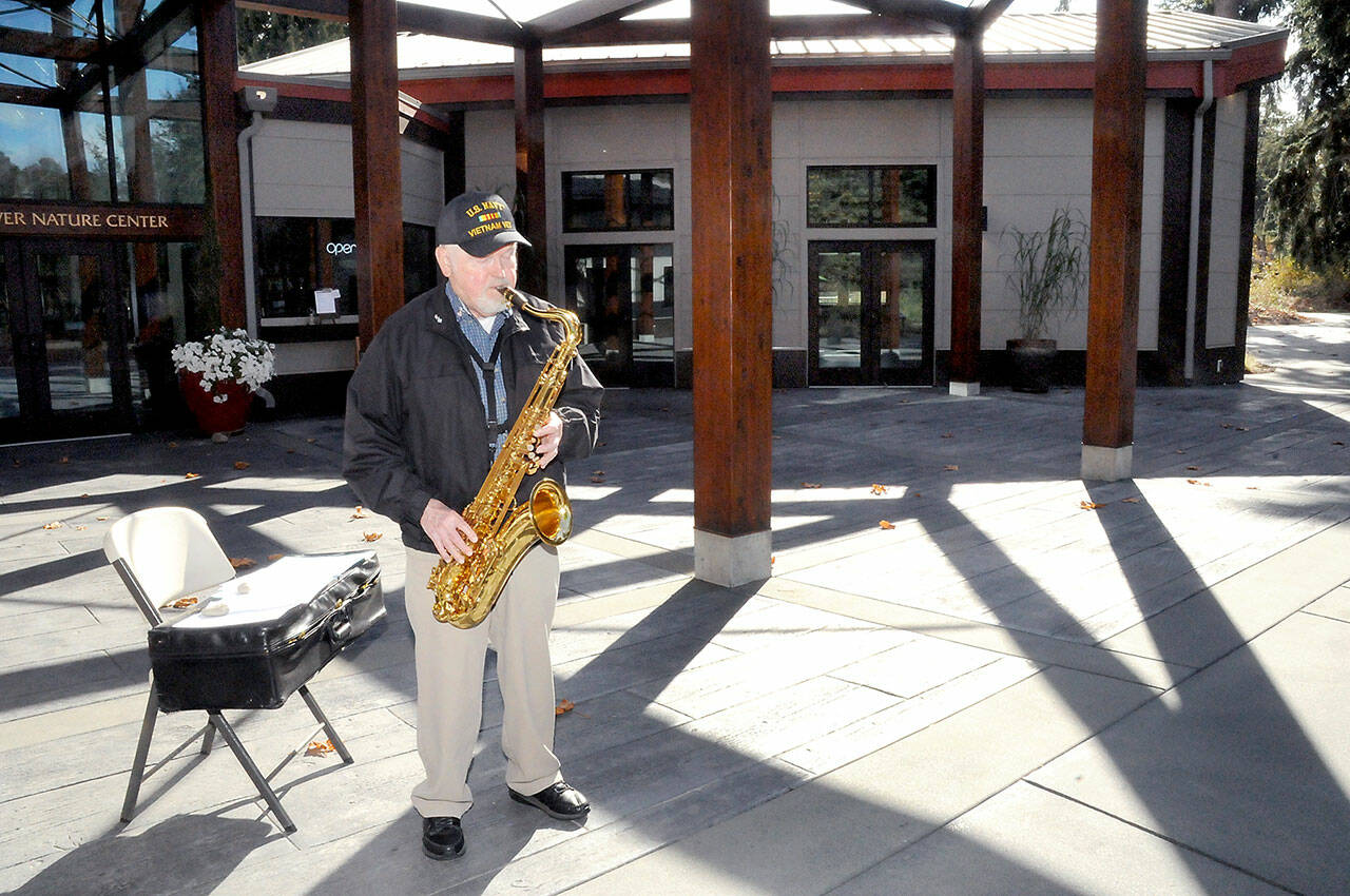 John Zuermer, 86, of Sequim plays his saxophone on the patio plaza at the Dungeness Nature Center at Railroad Bridge Park in Sequim. Zuermer, who regularly performs at the center from 11 a.m. to noon on Wednesdays and Saturdays, said he decided it would be a fun thing to do, keeping up his musical skills while playing for anyone who happened by. (Keith Thorpe/Peninsula Daily News)