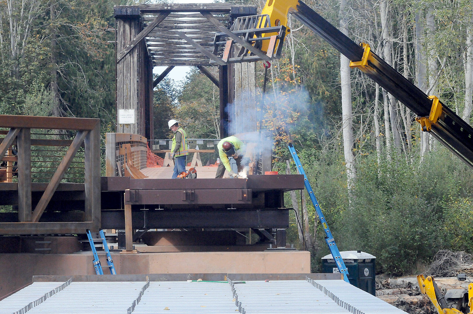A construction worker welds support pieces for a new pedestrian bridge connecting the historic railroad trestle over the Dungeness River to the Dungeness River Nature Center at Railroad Bridge Park in Sequim on Wednesday. (Keith Thorpe/Peninsula Daily News)
