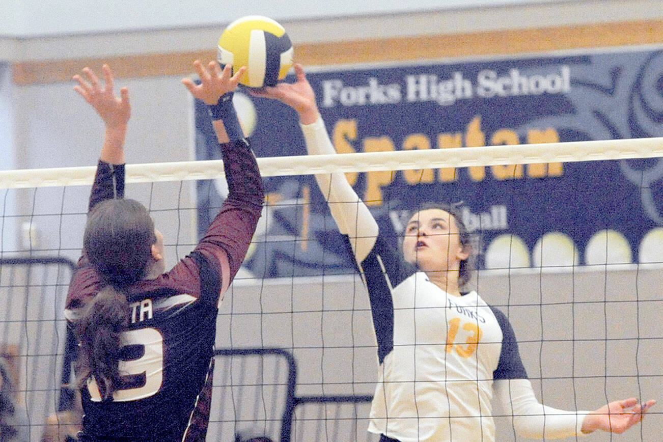Forks Kaidence Rigby (13) competes with Ocosta's Alexia Bradley (19) at the net in Forks Thursday evening where the Sparans defeated the Wildcats 3 to 0.  Photo by Lonnie Archibald.