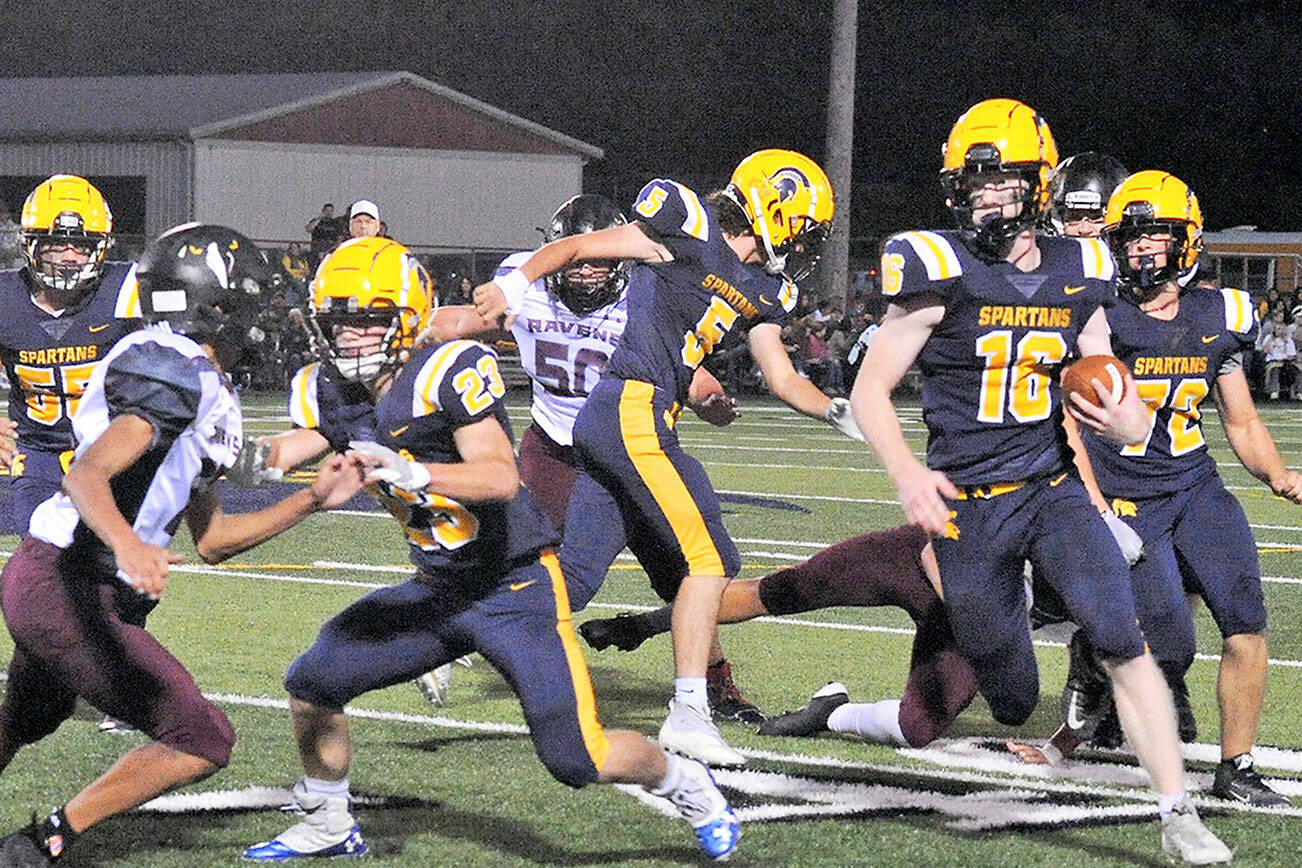 Lonnie Archibald/for Peninsula Daily News
Forks' Gunner Rogers runs with blockers from left Sloan Tumaua, Walker Wheeler, Landin Davis and Mathew Wallerstedt leading the way Friday night in Forks where the Raymond-South Bend Ravens defeated the Spartans 20 to 7.
