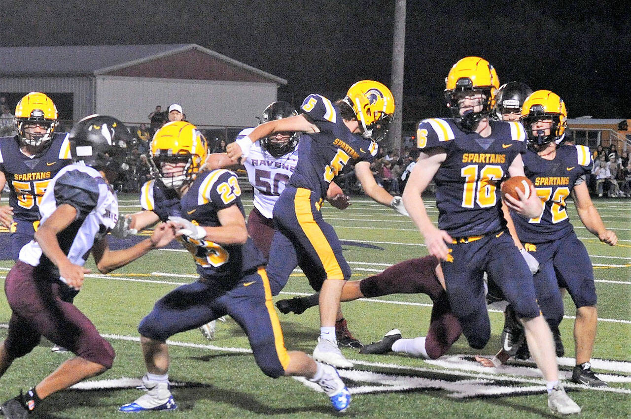 Forks’ Gunner Rogers runs with blockers from left Sloan Tumaua, Walker Wheeler, Landin Davis and Mathew Wallerstedt leading the way Friday night in Forks where the Raymond/South Bend Ravens defeated the Spartans 20 to 7 in conference play. Photo by Lonnie Archibald.