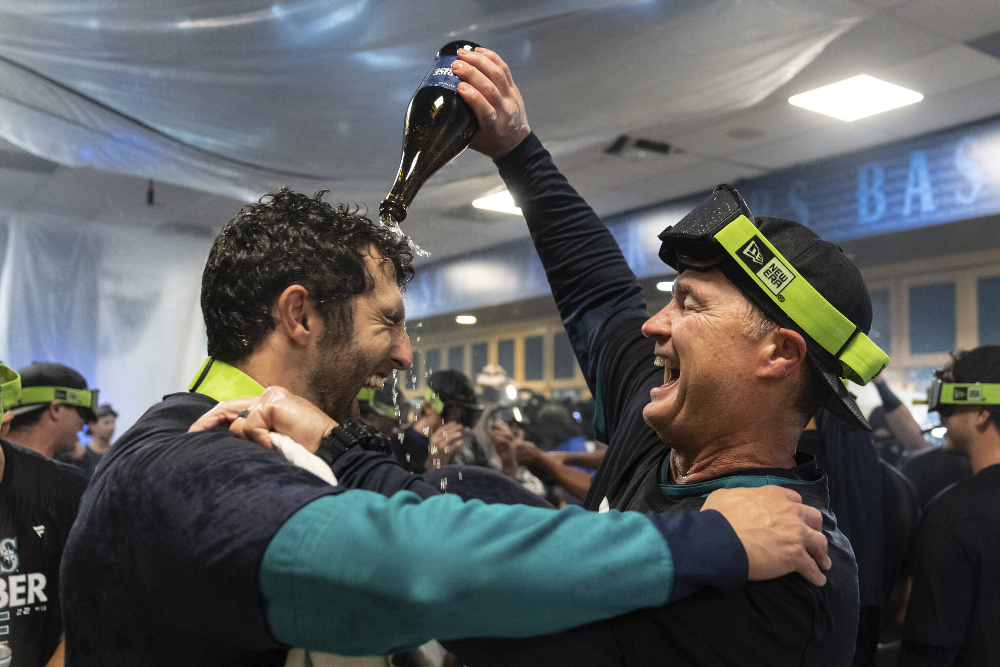 Seattle Mariners manager Scott Servais, right, celebrates in the clubhouse after the team’s baseball game against the Oakland Athletics, Friday, Sept. 30, 2022, in Seattle. The Mariners won 2-1 to clinch a spot in the playoffs. (AP Photo/Stephen Brashear)