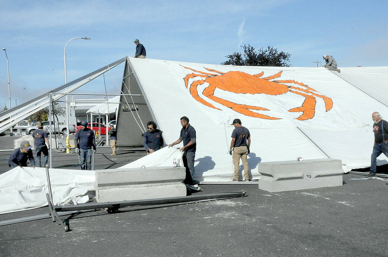 A crew from Bothel-based Grand Event Rentals erects a dining tent in the parking lot of the 48 Degrees North restaurant along the Port Angeles waterfront on Wednesday. The tent will serve as the focal point for food and entertainment for this weekend’s three-day Port Angeles Crab Festival, which begins Friday. (Keith Thorpe/Peninsula Daily News)