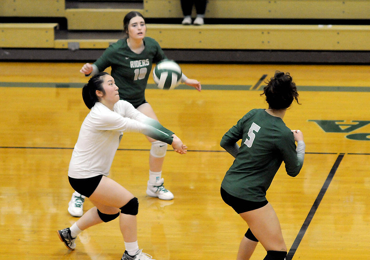 KEITH THORPE/PENINSULA DAILY NEWS Port Angeles libero Cindy Liang, center, passes the ball as fellow back row teammates Jasmine Messinger, upper left, and Karma Williams look on during Thursdays match against Kingston at Port Angeles High School.