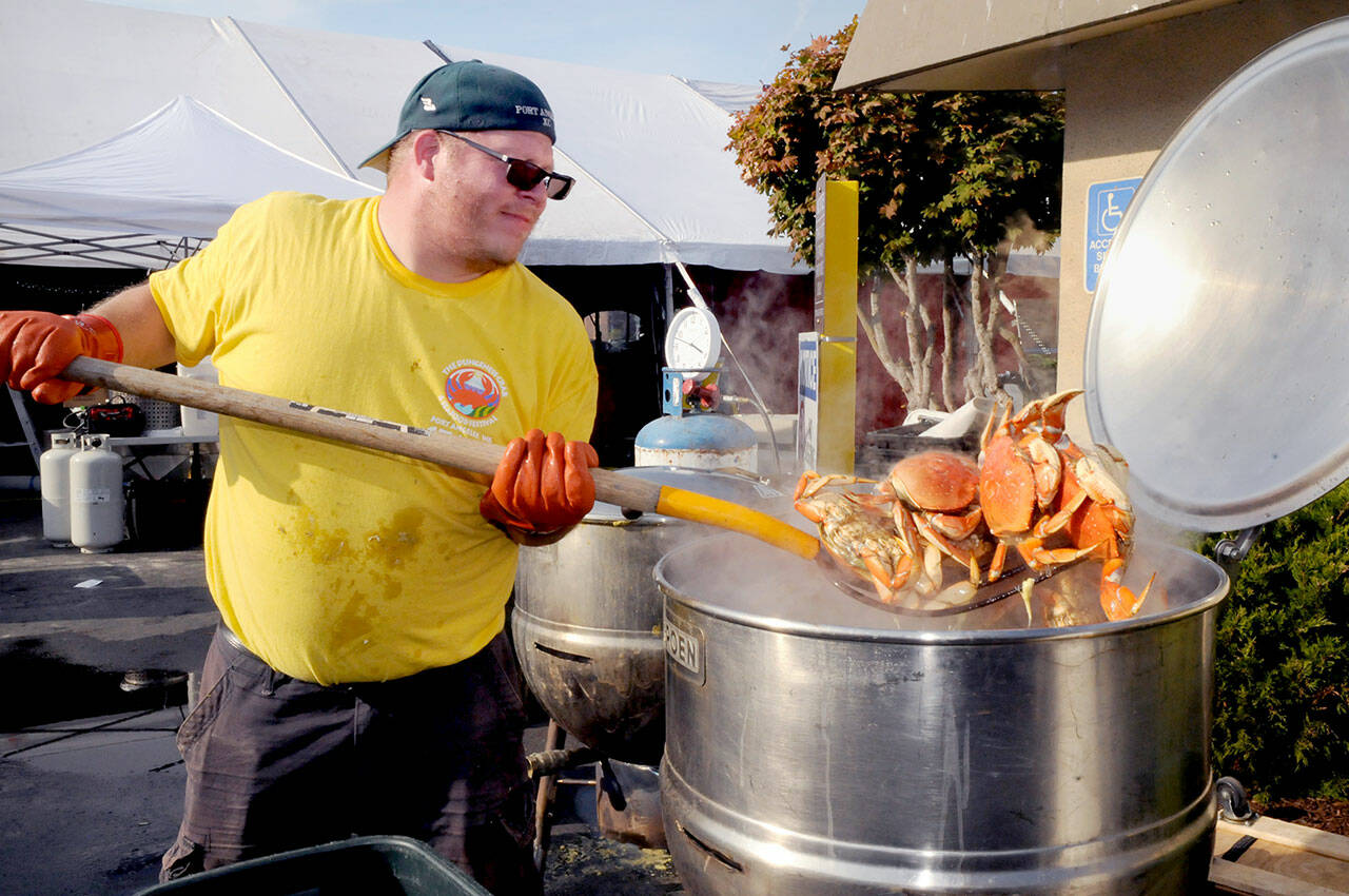 Crab crew member Jacob Brown of Port Angeles pulls cooked crab from a boiler on Thursday in preparation for the opening of the Dungeness Crab and Seafood Festival on the Port Angeles waterfront. The three-day festival begins today and runs through Sunday. For more information, see Page A6. (Keith Thorpe/Peninsula Daily News)
