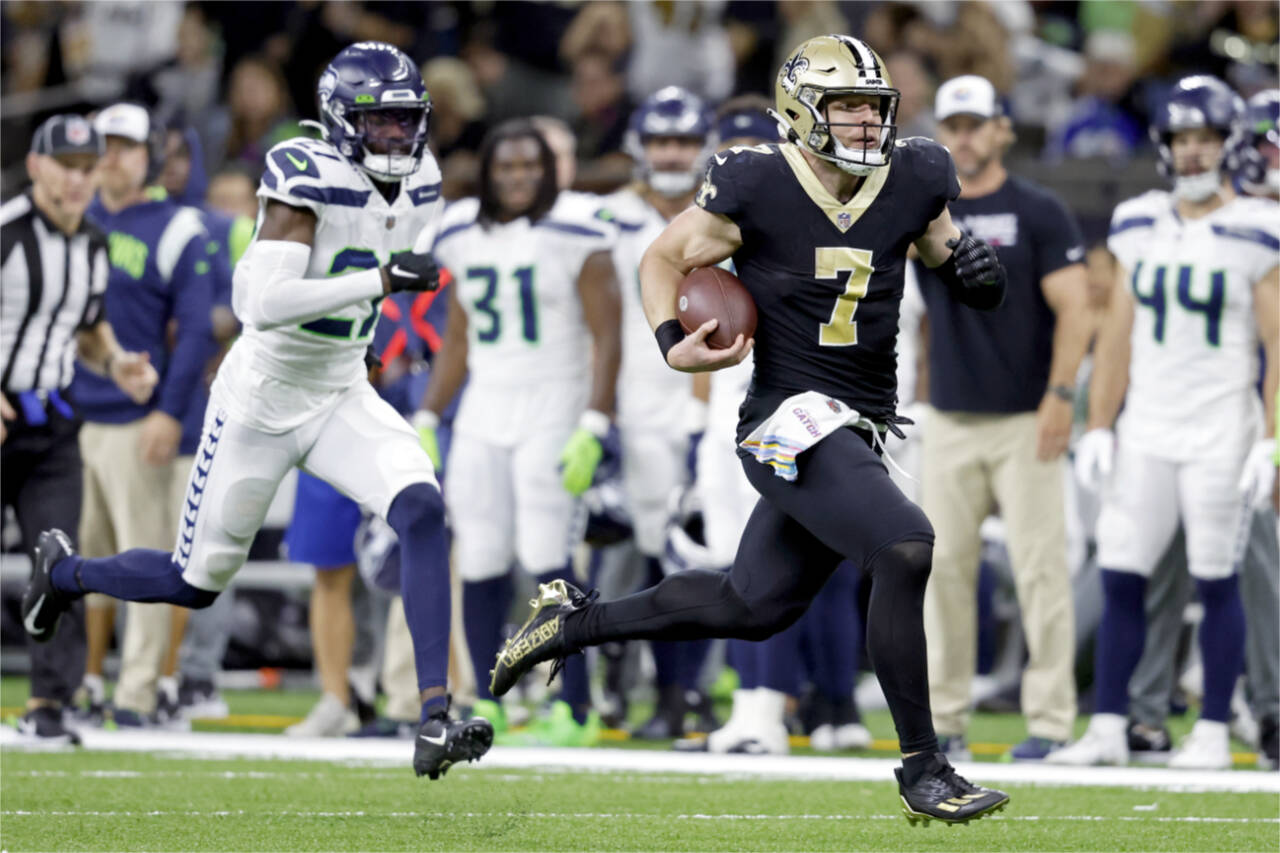 New Orleans Saints tight end Taysom Hill (7) runs the ball past Seattle Seahawks cornerback Tariq Woolen (27) to score a touchdown Sunday in New Orleans. (AP Photo/Tyler Kaufman)
