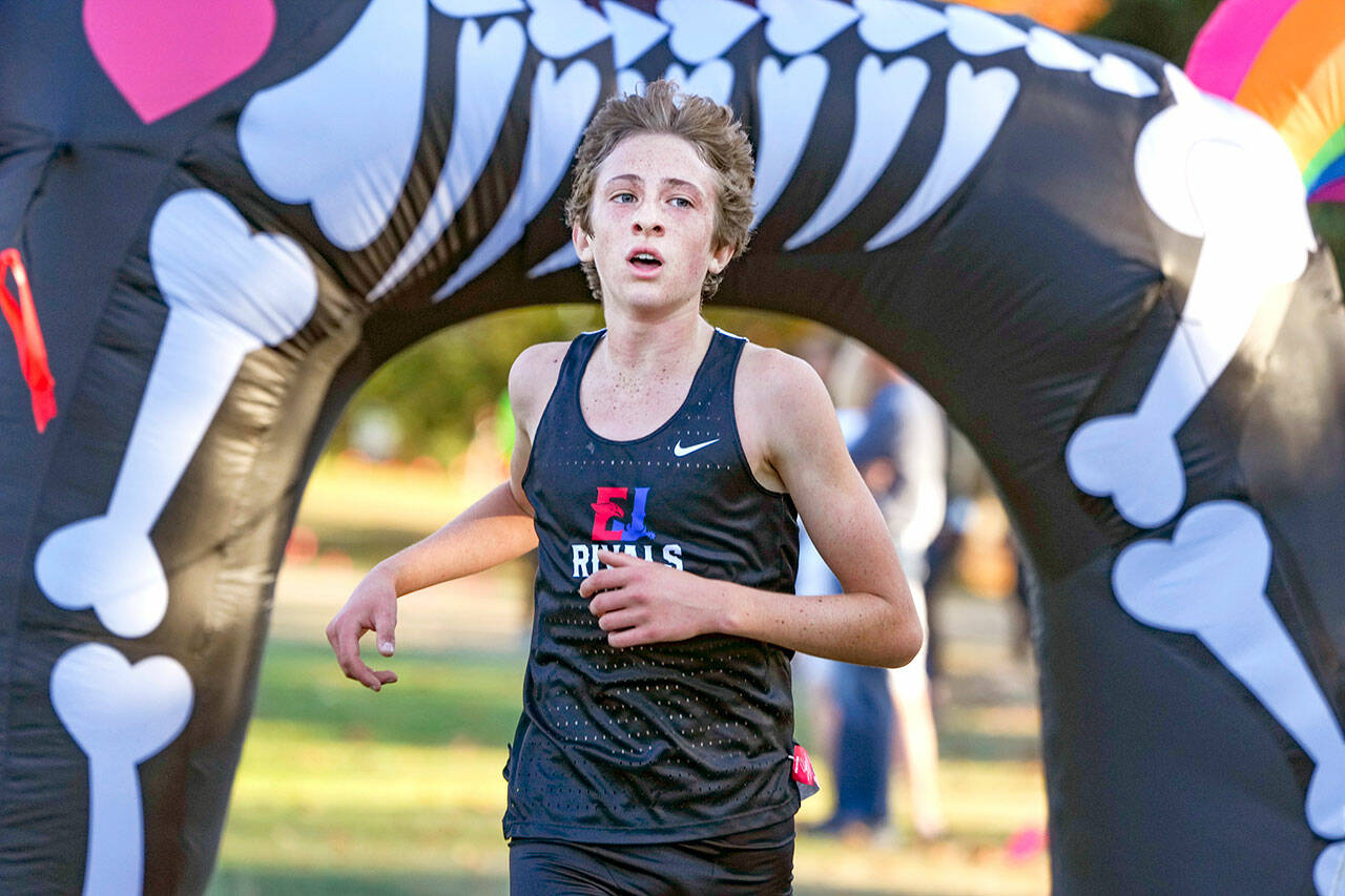Steve Mullensky/for Peninsula Daily News East Jefferson Rival Soare Johnston crosses under the inflatable unicorn finish line to win the Boy’s 5,000 meter Cross Country race on Tuesday at Port Townsend Golf Course.