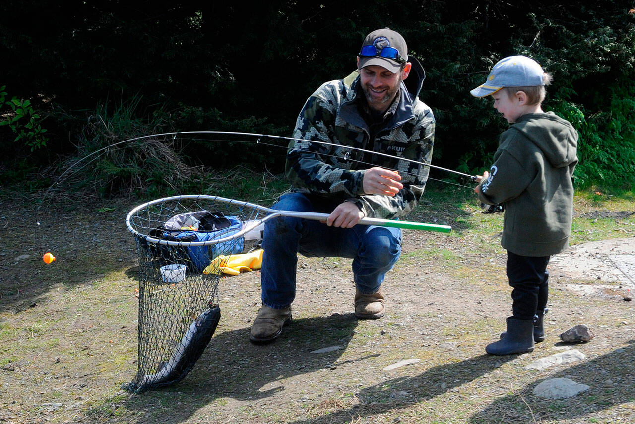Craig Larson helps his 3-year-old son Barrett net a rainbow trout during Kids Fishing Day on April 23. It was Barrett’s first catch ever, Larson said. (Olympic Peninsula News Group Matthew Nash)