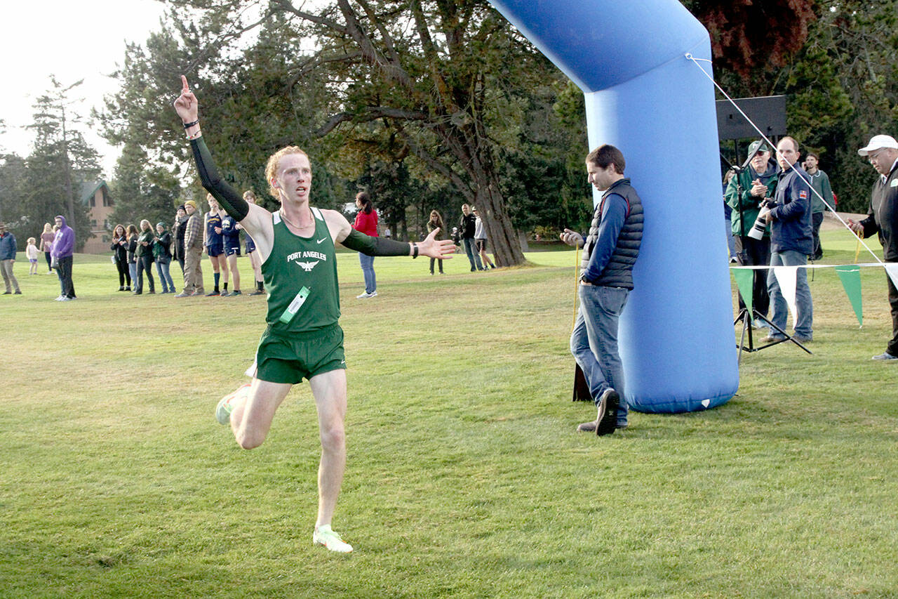 Dave Logan/for Peninsula Daily News
Port Angeles senior Jack Gladfelter crosses the finish line in 15 minutes 27 seconds to repeat as boys champion at the 2022 Olympic League Cross Country Championships on Thursday at The Cedars at Dungeness.