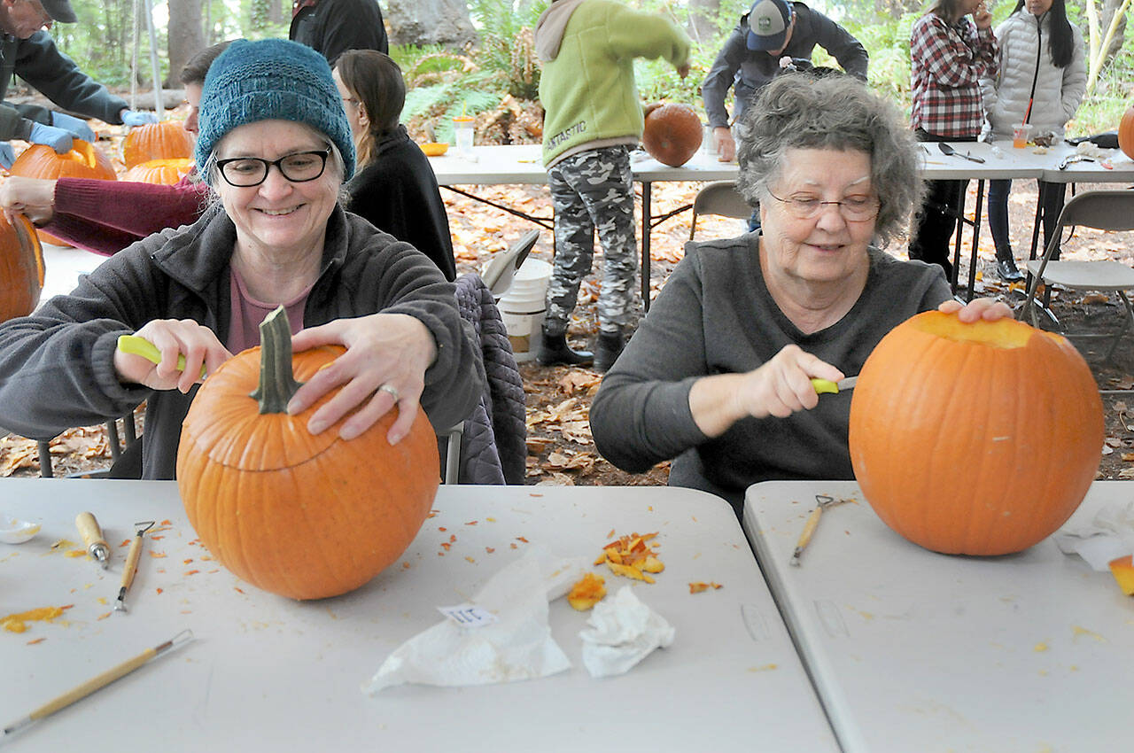 Kathy Durr, 70, left, and Charle Crocker, 69, both of Port Angeles, try their hands at carving jack-o-lanterns during a pumpkin carving workshop on Saturday at the Port Angeles Fine Arts Center. The workshop, which drew about 50 participants, was part of the center’s second annual Celebration of Shadows, a tribute to the season of Halloween. The event also included a mask-making workshop, a carved pumpkin contest, spooky walks and an outdoor movie. (Keith Thorpe/Peninsula Daily News)