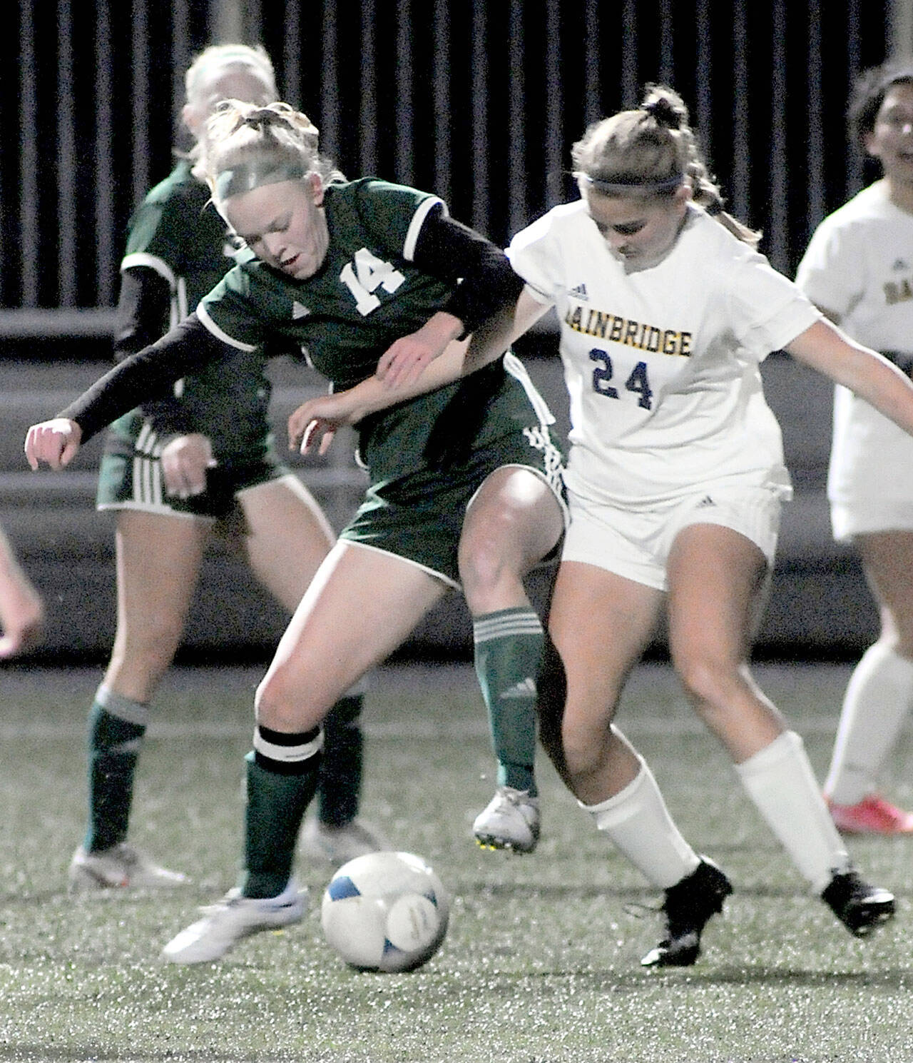 Port Angeles’ Anna Petty, left, fights for control with Bainbridge’s Grace Rich on Tuesday at Peninsula College. (Keith Thorpe/Peninsula Daily News)