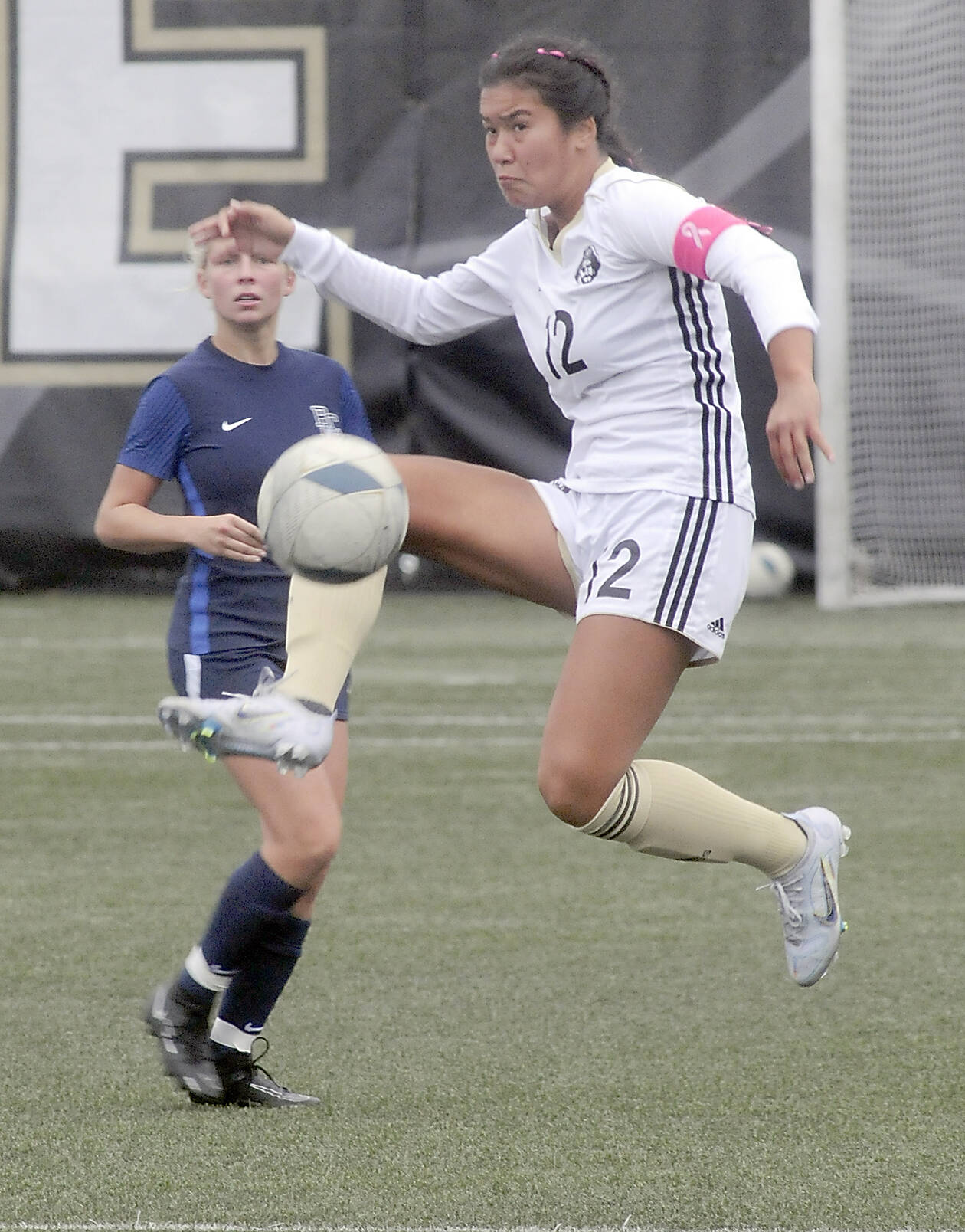 KEITH THORPE/PENINSULA DAILY NEWS Peninsula's Keilee Silva kicks high for the ball while Bellevue's Daisy Morris looks on during Wednesday's game in Port Angeles.
