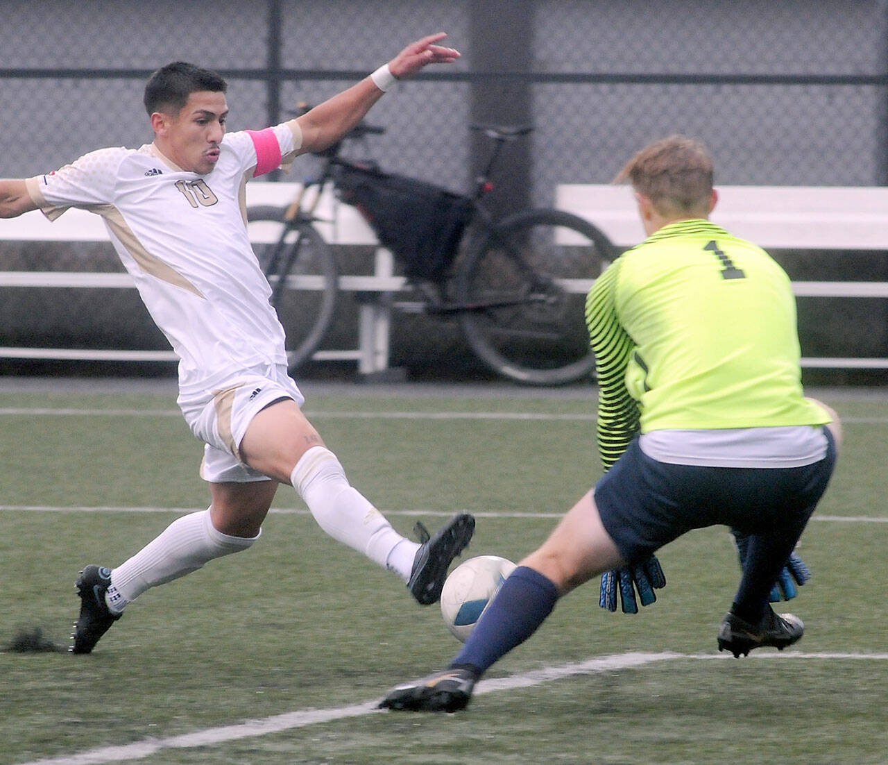 KEITH THORPE/PENINSULA DAILY NEWS Peninsula's Fernando Tavares (left) charges at Bellevue goaltender Nicola Luongo, narrowly missing a goal in the first quarter on Wednesday at Wally Sigmar Field.