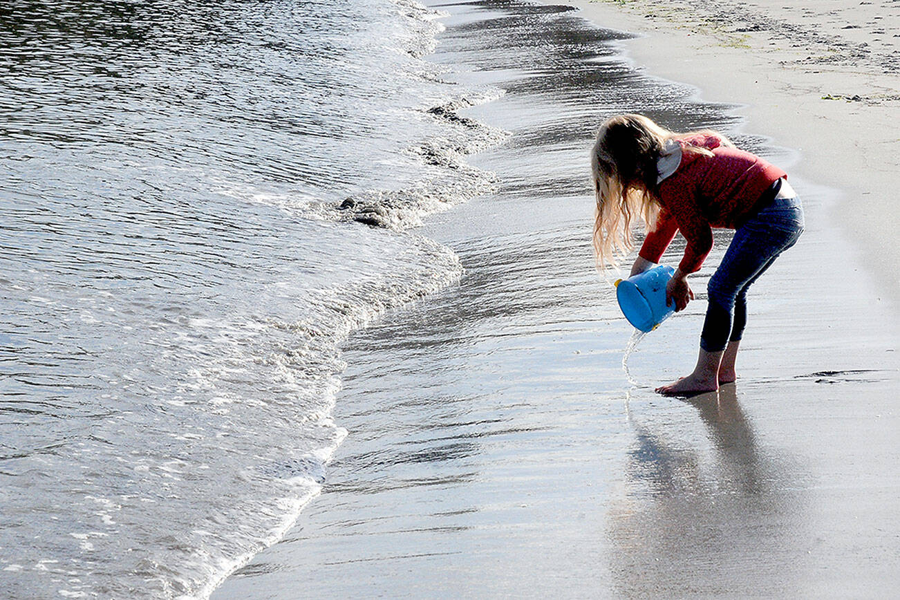 KEITH THORPE/PENINSULA DAILY NEWS
Four-year-old Marlee Sargent of Port Angeles plays with a bucket and water on Friday on the shore of Port Angeles Harbor. The youngster and her family were taking advantage of a warm autumn day to pay a visit to Hollywood Beach in Port Angeles.