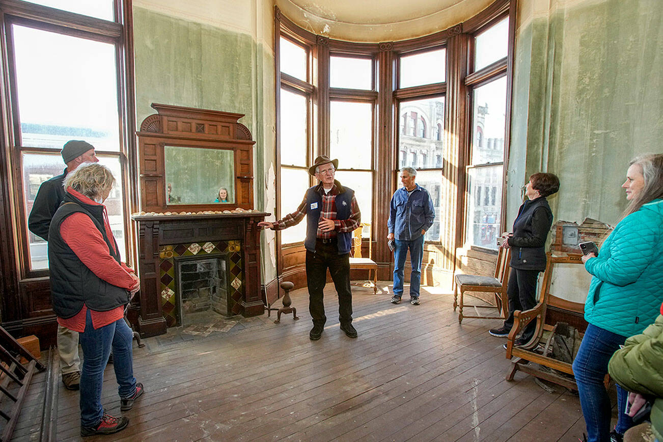Steve Mullensky/for Peninsula Daily News

Port Townsend’s Harry Dudley, center, whose family has owned the historic Hastings building in downtown Port Townsend since it was built in 1889, shows off an Italian stone fireplace, one of the highlighted features on the Haunted Histories and Mysteries of Port Townsend tour produced by the Main Street Organization, as he conducts a tour on Friday.  For more about the multi-venue festival, which continues today, see ptmainstreet.org.