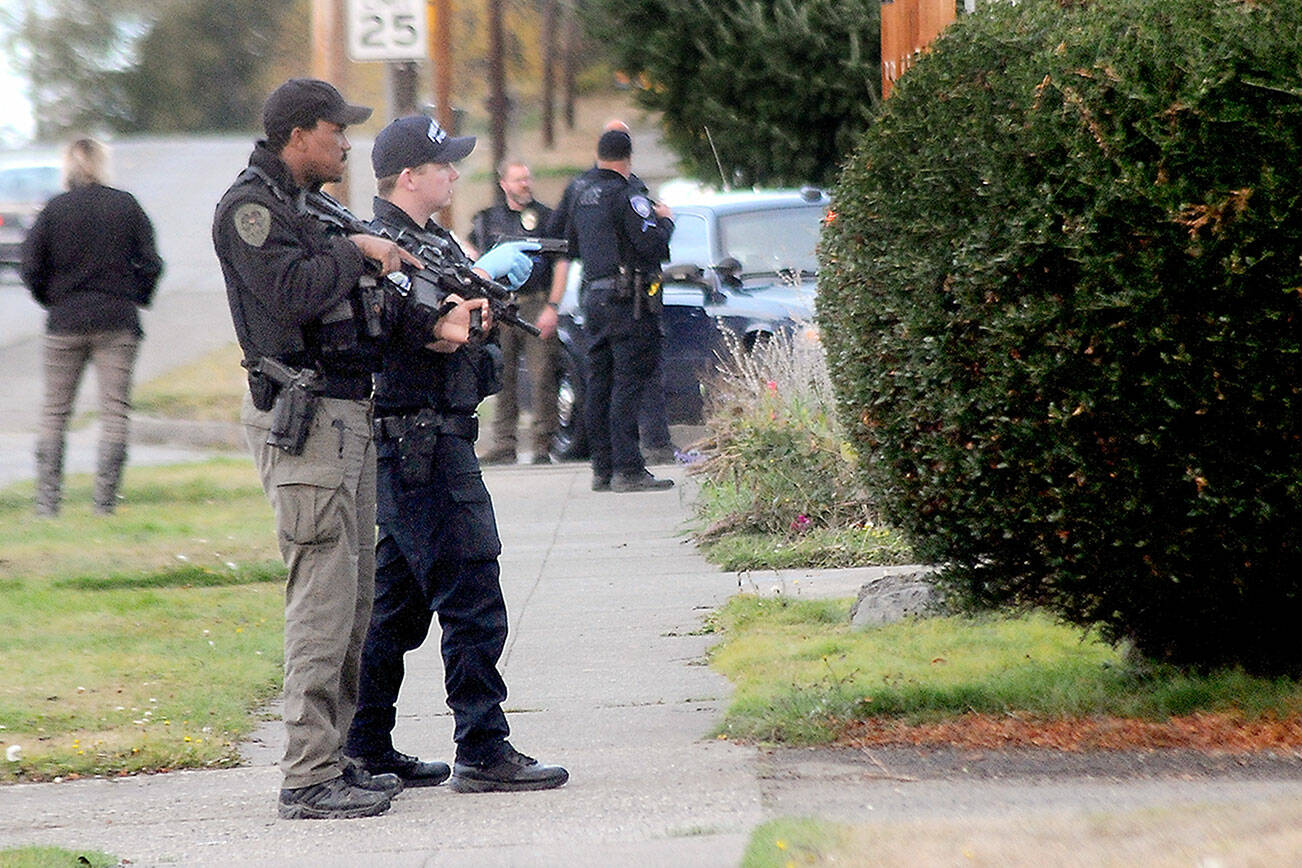 Armed police keep watch on an alley between Fifth and Sixth streets at Oak Street in Port Angeles after a report of shooting from a house in the 200 block of West Sixth Street on Tuesday. (Keith Thorpe/Peninsula Daily News)