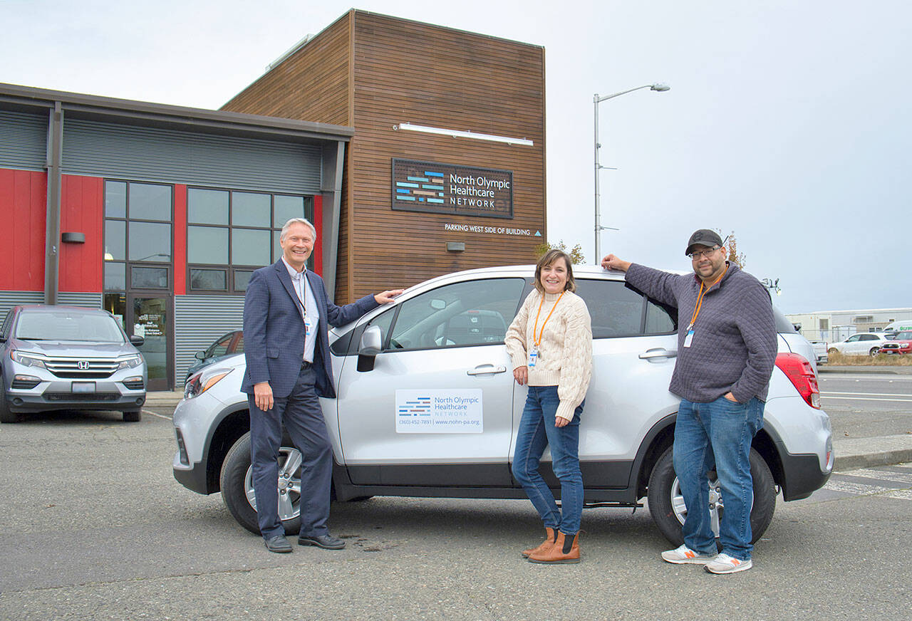 North Olympic Healthcare Network staff posing with a new Chevy Trax to be used for community outreach are, from left, CEO Michael Maxwell, MD; Community Health Worker Lauryn Garrett and Outreach and Navigation Manager Carlos Osorio.