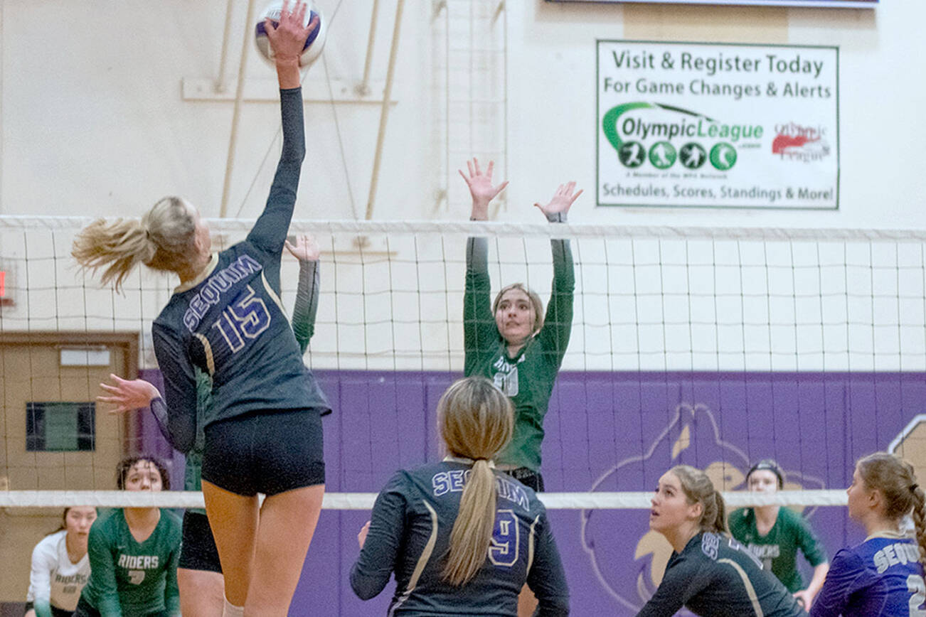Sequim Gazette photo by Emily Matthiessen / Sequim's Kendall Hastings (15) looks to hit past the block of Port Angeles' Jasmine Messinger in an Olympic League tournament game on Nov. 3 in Sequim. The host Wolves topped PA's Roughriders in three games.