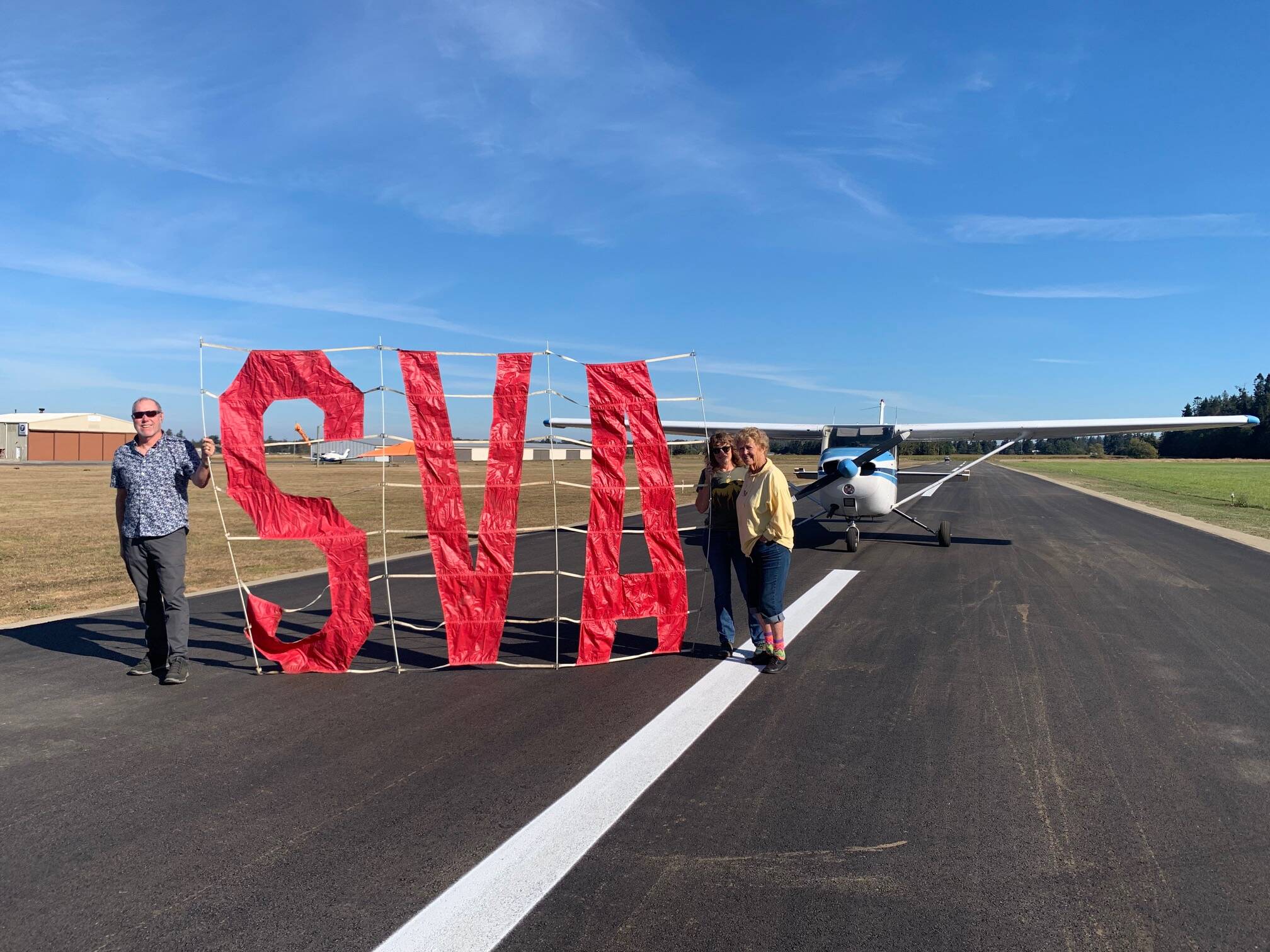Submitted photo / Sequim Valley Airport owners Andy and Jane Sallee and Emily Westcott celebrate the completion of a project to rehabilitate, pave and restripe the airport runway.