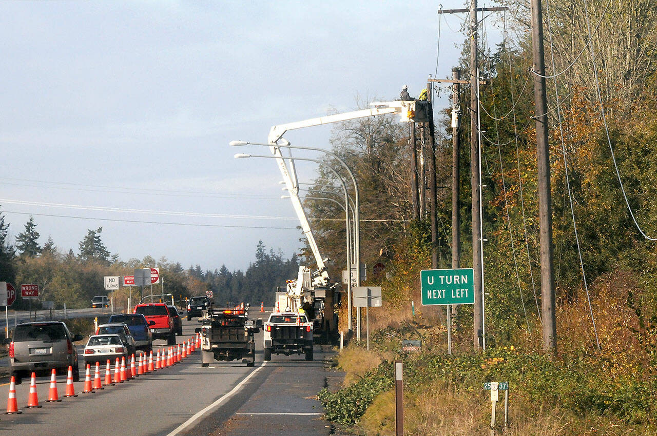 A line crew from Clallam PUD works to repair a powerline along U.S. Highway 101 west of Barr Road on Saturday. (Keith Thorpe/Peninsula Daily News)