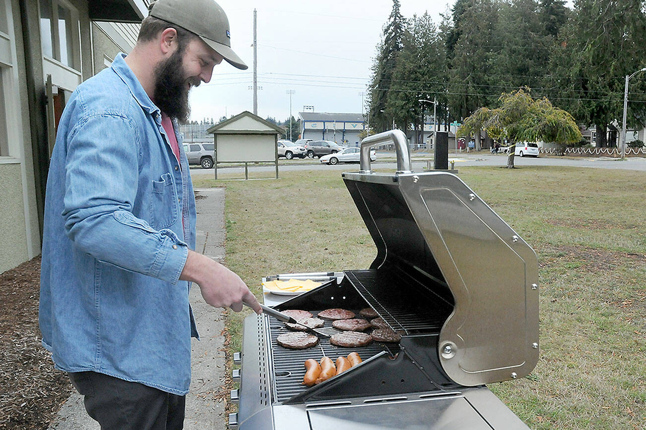 Levi Douglas, Clallam County Veterans program coordinator and U.S. Air Force veteran, cooks burgers and hot dogs during a Veterans Day barbecue for vets and their families at the Clallam County Veterans Center in Port Angeles. The event was one of several across the North Olympic Peninsula honoring those who served their country. (Keith Thorpe/Peninsula Daily News)
