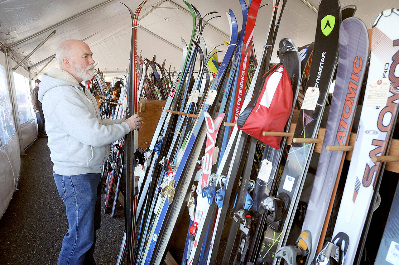 Chris Noble of Port Angeles looks through a selection of used skis during Saturday’s annual Hurricane Ridge Ski Club Outdoor Gear Swap at the Coho Ferry parking lot in downtown Port Angeles. Skis, boots, poles, sports clothing and accessories were available through consignment with proceeds benefiting the Hurricane Ridge Ski Team and the Surfrider Foundation. The event preceded this coming Saturday’s Winterfest at the Vern Burton Community Center in Port Angeles, which will support capital improvements to the ski area and scholarships to underprivileged children. Tickets can be purchased online at www.hurricaneridge.com. (Keith Thorpe/Peninsula Daily News)