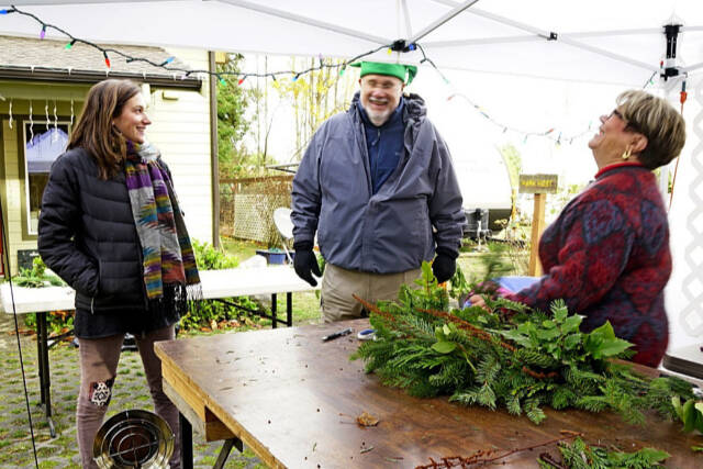 Tuttie Peetz, right, brings her wreath-making equipment and piles of greens, cones and ribbons to the River Center Holiday Nature Mart this weekend. The sale of handcrafted items, holiday wreaths and arrangements, baked goods and candy, is set for Saturday and Sunday to support the Dungeness River Nature Center’s education programs. (Submitted photo)