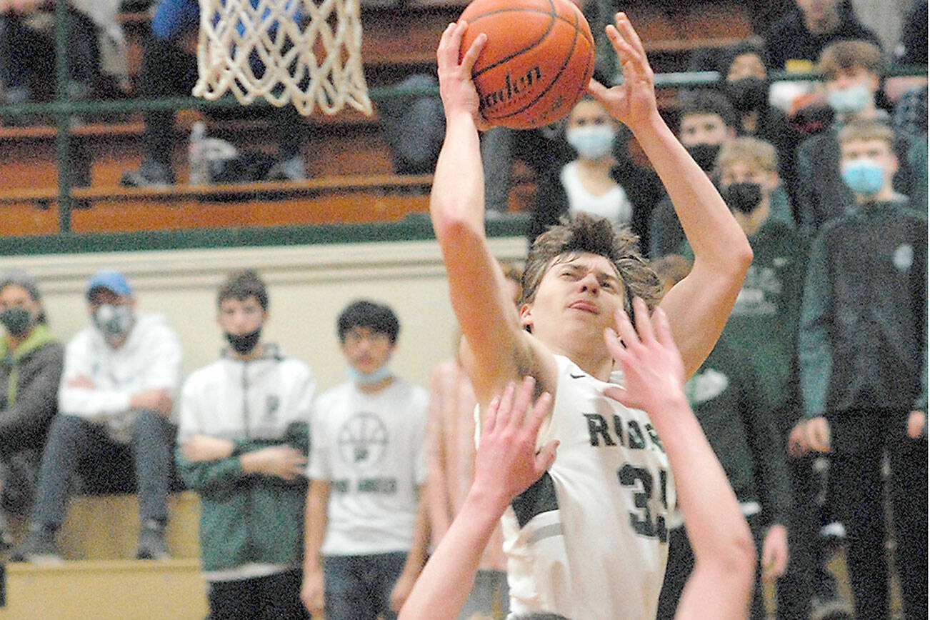 Keith Thorpe/Peninsula Daily News
Port Angeles' Parker Nickerson, top, take aim at the basket as Bainbridge Island's James Carey defends the lane on Tuesday in Port Angeles.