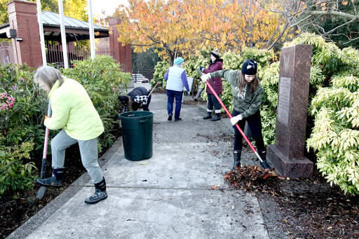 Terri Wood of First Federal, left, and Trisha Parker of Port Angeles Realty, right, join more than a dozen volunteers in cold conditions to help clean up Veterans Park on Lincoln Street. The Port Angeles Association of Realtors joined 4PA to spruce up organic material, trash and graffiti on many walls. (Dave Logan/For Peninsula Daily News)