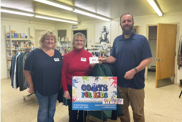 Coats For Kids organizers Karen Lewis and Heidi Albrecht present Levi Douglas, Clallam County Veterans Program Coordinator, with more than $1,200 worth of certificates for veterans at the Northwest Veterans Resource Center.