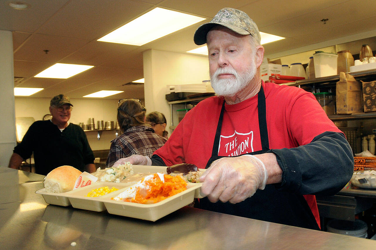 Volunteer Doug Crabb of Sequim serves a tray of traditional fixings during a Thanksgiving Eve lunch at the Salvation Army’s soup kitchen on Wednesday in Port Angeles. The free meal was one of several being offered across the North Olympic Peninsula during the Thanksgiving holiday. (Keith Thorpe/Peninsula Daily News)