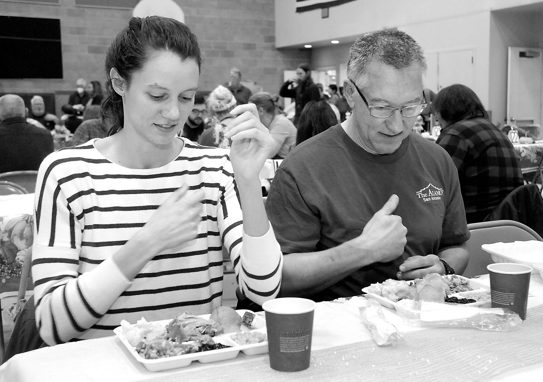 KEITH THORPE/PENINSULA DAILY NEWS
Cecilia Stevenson, of Dallas, left, and her father, Will Stevenson of Port Angeles, say a blessing before enjoying a Thanksgiving meal in the fellowship hall of Queen of Angeles Catholic Church in Port Angeles. The church offered a traditional Thanksgiving dinner for the community, with several hundred diners taking advantage of the in-house meal with numerous other dinners sent out for in-home dining.